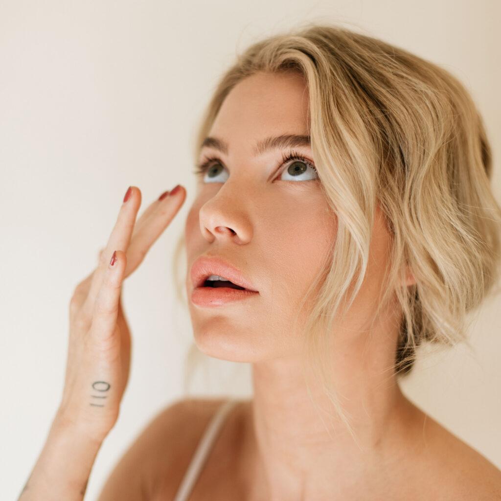 Women looks up with fingers placed on face