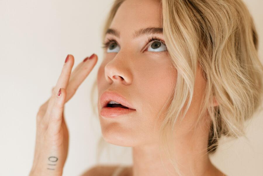 Women looks up with fingers placed on face